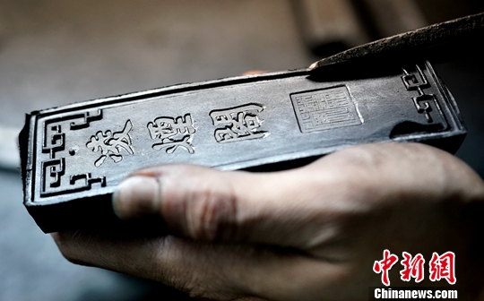 “大有制墨”工坊主人陈俊天给成型的墨块修边。中新社记者 张宇 摄 “大有制墨”工坊主人陈俊天给成型的墨块修边。中新社记者 张宇 摄