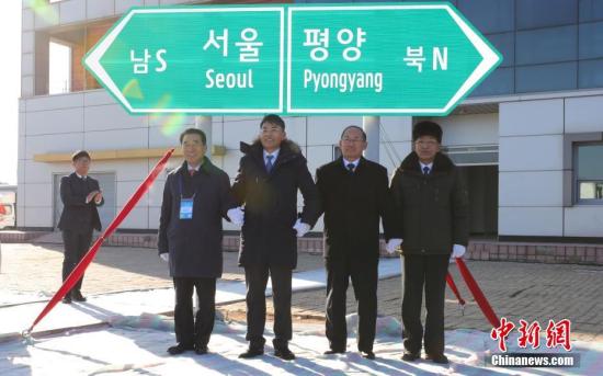 12月26日，韩朝举行京义线和东海线铁路及公路连接工程动工仪式。图为韩朝代表为韩朝跨境公路指示牌揭幕。中新社发 “联合采访图”供图